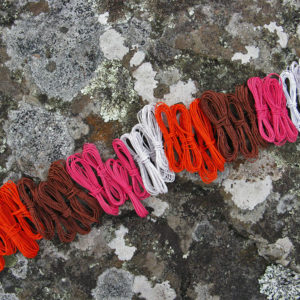 Coils of white, orange, brown and pink telephone wire on a lichen-covered rock at Hellfire Bluff in Tasmania.