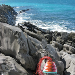 Wire basket in progress on the stunningly weathered rocks at Antechamber Bay, Kangaroo Island. Intense blue sea and Cape Jervis in the background.