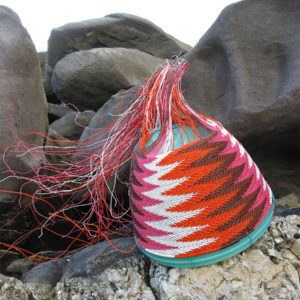 Close-up of a chevron-patterned telephone-wire basket nestled on the glistening rocks at Antechamber Bay, Kangaroo Island.