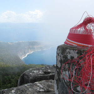 Wire basket on a lichen-covered rock, in the clouds on top of Mt Bishop and Clerk, Maria Island, Tasmania.