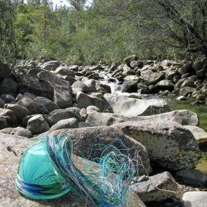 Telephone wire basket in progress, on the rocky shores of North West Bay River, near Cathedral Rock, Tasmania.