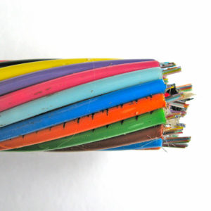 A close-up of the brightly coloured, helically arranged plastic tubes that enclose optic fibres, showing the sticky water-repellent gel coating.